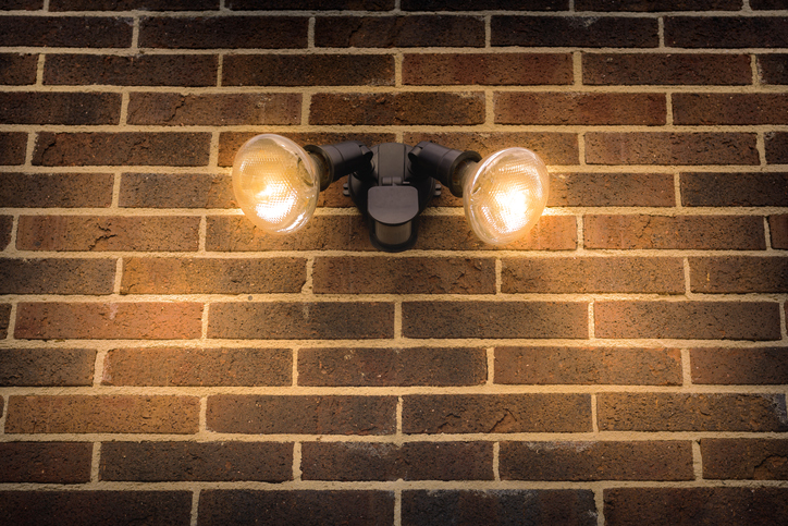 A motion sensor light is illuminated on the side of a home