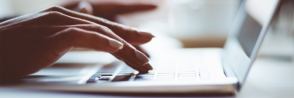 Hands typing on a laptop