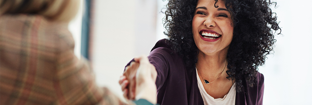 A woman shakes hands with a successful female job candidate