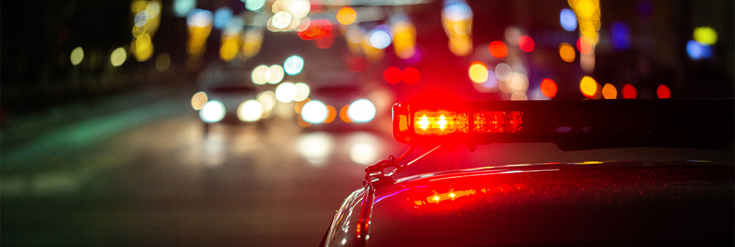 A police car at night, with bokeh of lights in the background