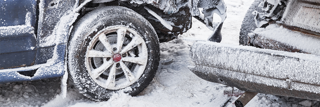 Two damaged vehicles covered in snow