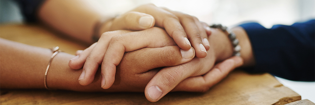 Hand holding another hand in support