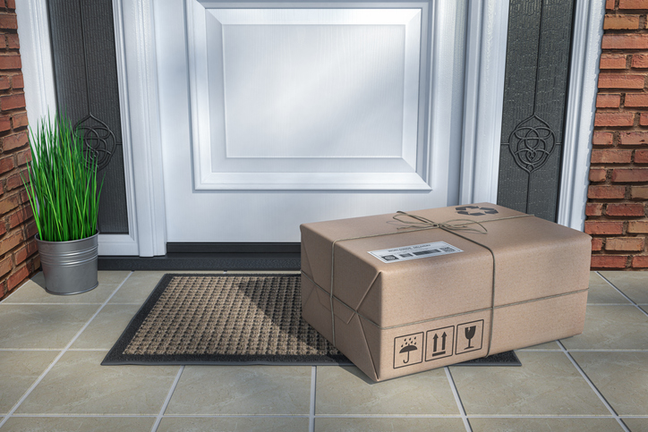 A cardboard box sits unattended on a front porch