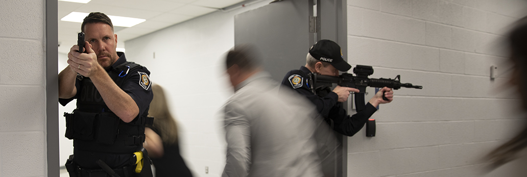 People fleeing a building as police enter