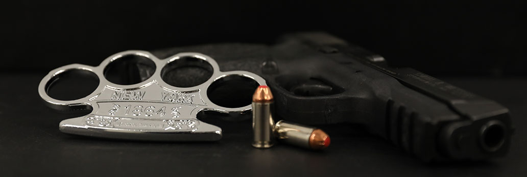 Firearm with bullets and brass knuckles on a table
