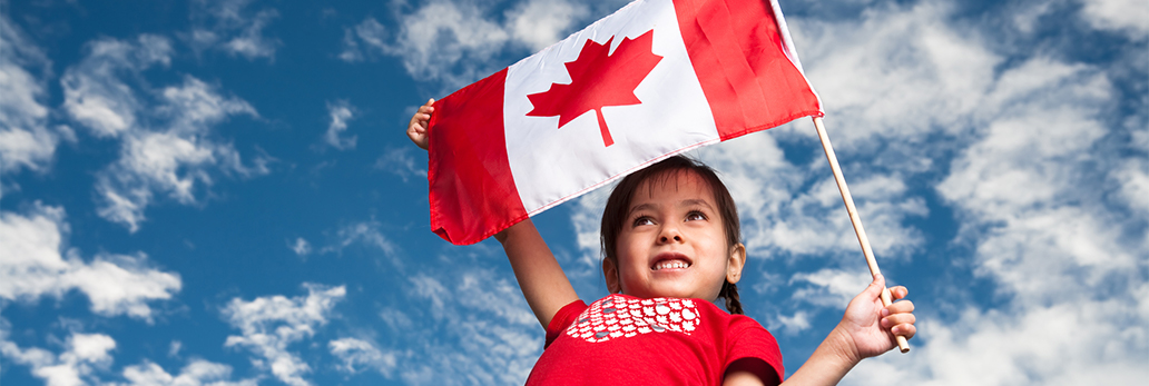 A young girl holds a Canadian flag