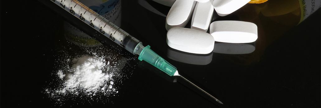 Powder, a syringe and pills are on a table