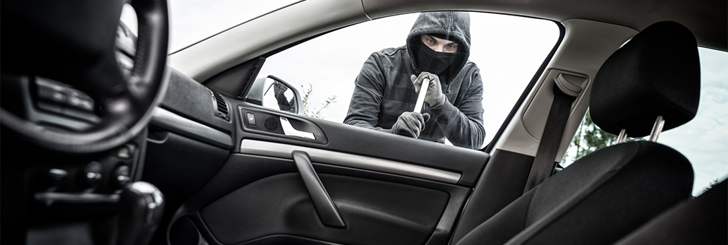 A male attempts to break into a vehicle