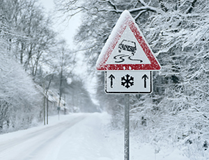 Snow-covered road with a warning sign