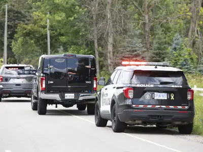 HRPS vehicles with lights on, on the side of a roadway