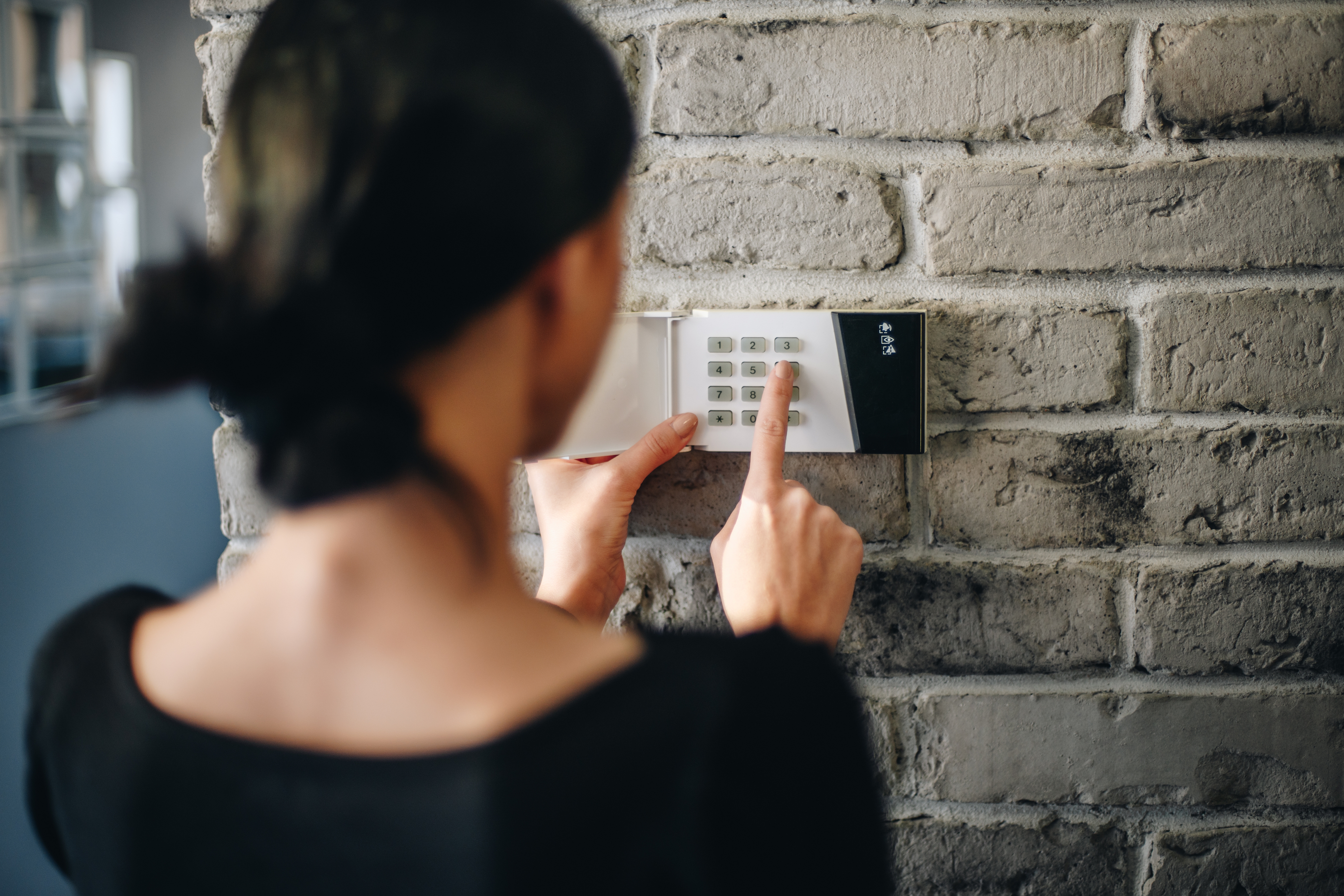 Woman arming a home security system